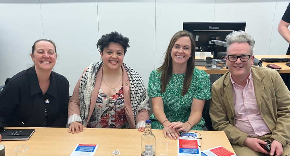 The panel sitting at a table in a row - me, Clau, Emma and Andrew