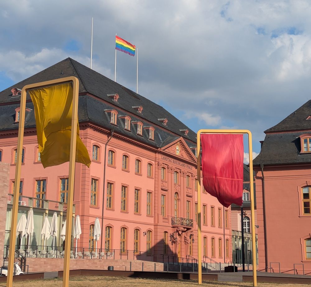 Das rheinland-pfälzische Landtagsgebäude. Darauf weht eine Regenbogenfahne.