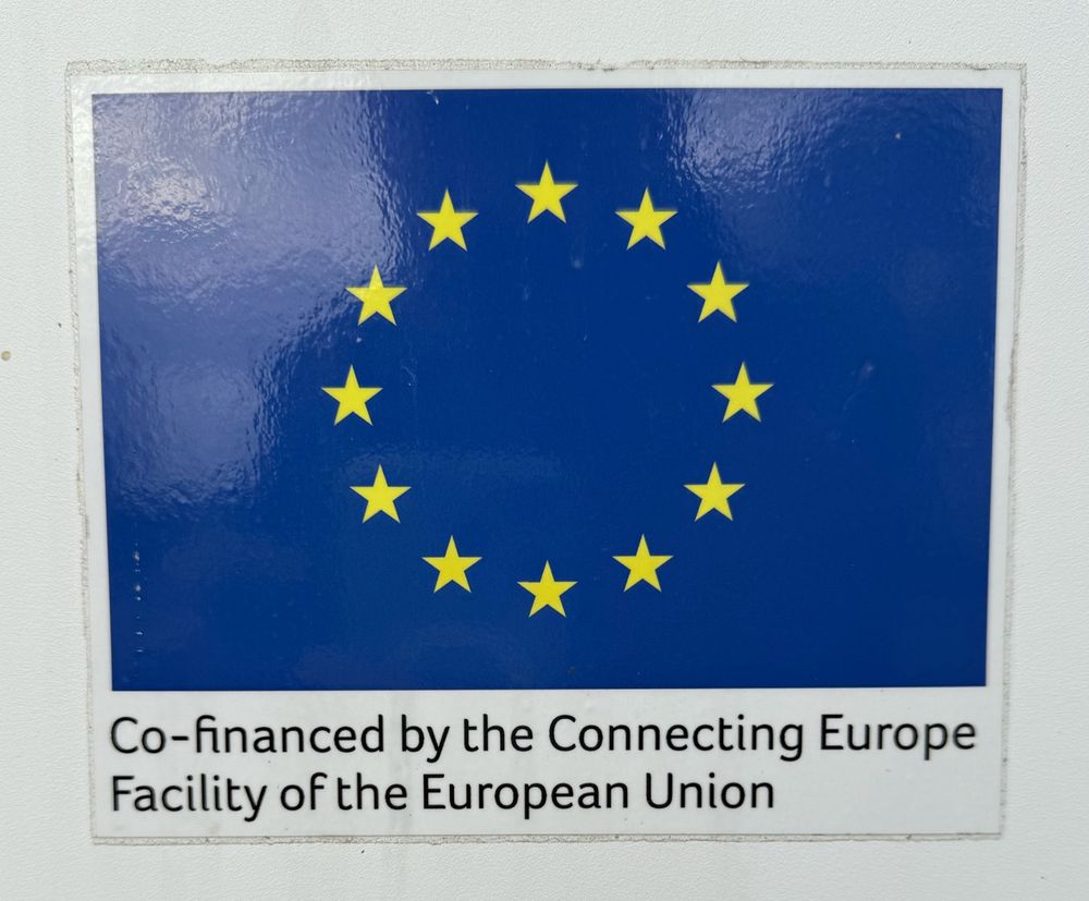 Sign on EV charger reading “co-financed by the Connecting Europe Facility of the EU”