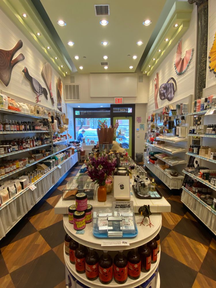 A view from the other end of the store. The middle table has “tube wringers” for a sale, a product from Oregon which is featured as the “tourist of the month”—one product per month highlighted that is not local to the area. 