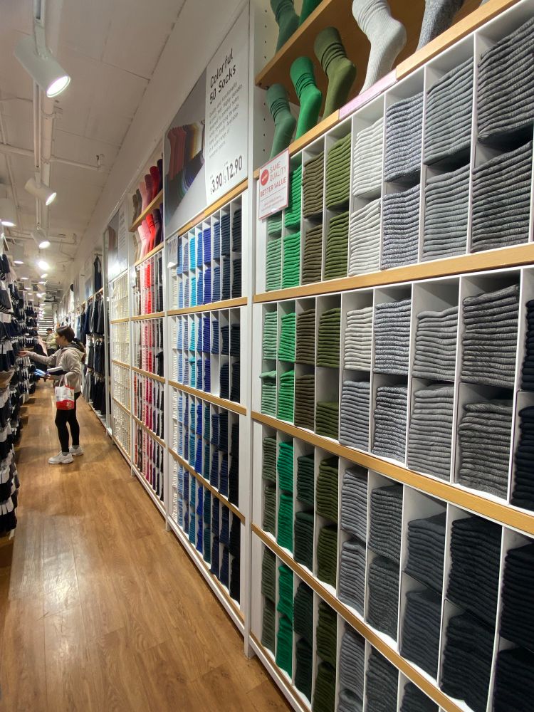 Hundreds of tee shirts stacked by color fill the wall in the Men’s department 