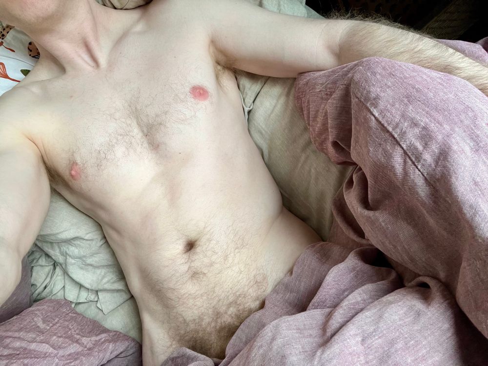 My naked torso lying in bed 