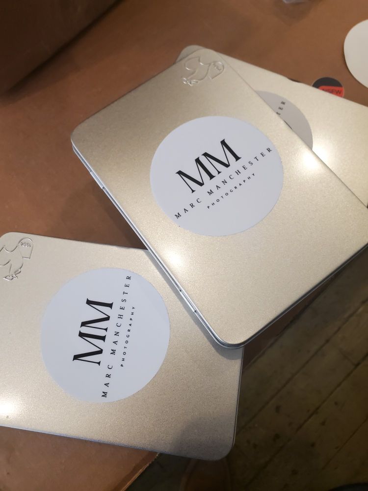 4x6" tin boxes with the Marc Manchester labels affixed. The tins hold 14 images and 14 poems, the 13 photos from the show and one that couldn't be hung.