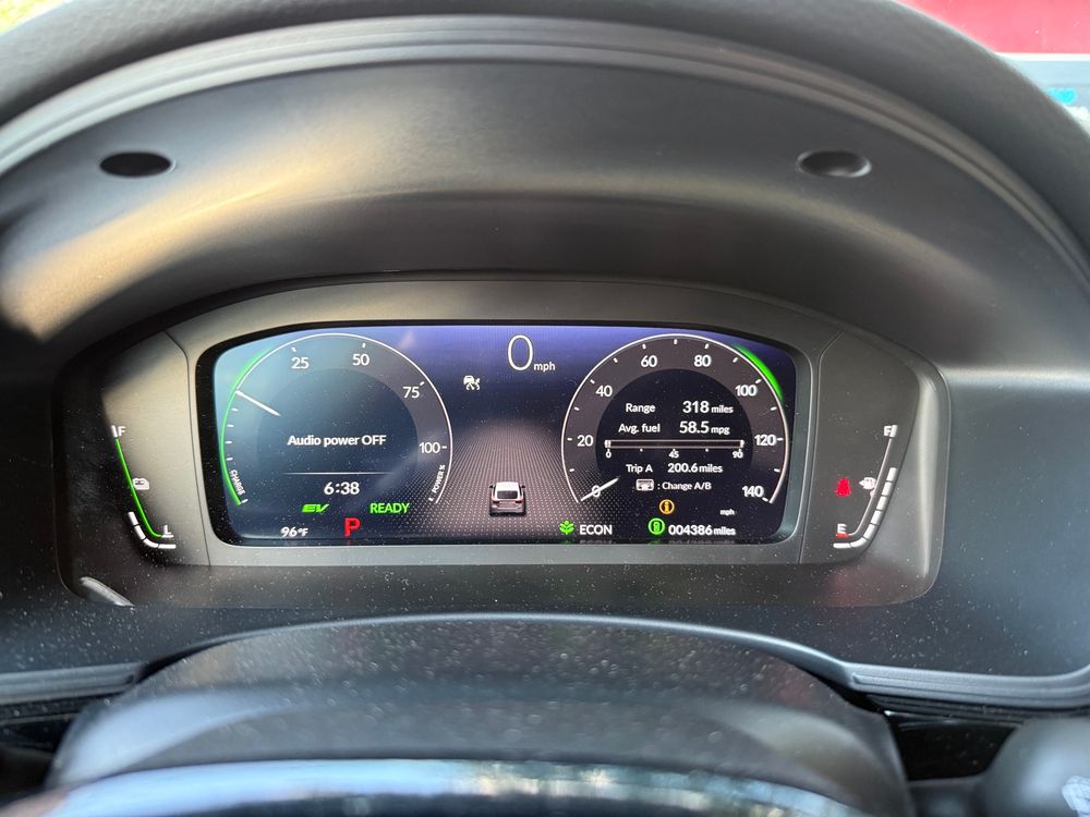 Dials in the dashboard of a 2025 Honda Civic Hybrid. The display on the right reads 58.5 miles per gallon average fuel economy over 200 miles.