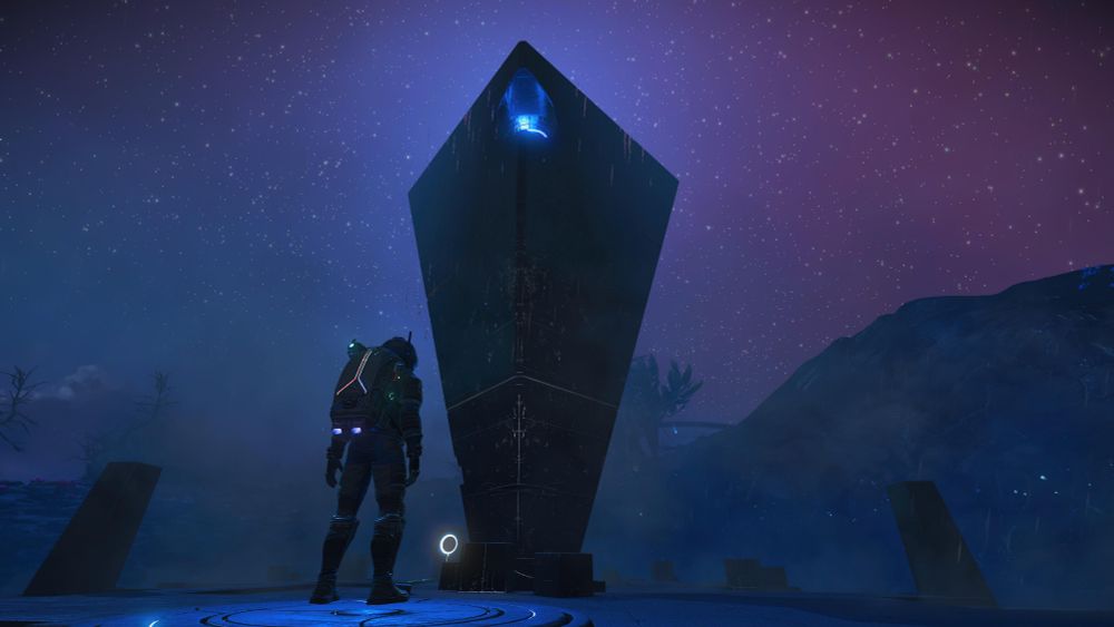 Screenshot from No Man's Sky.
My character is standing in front of an alien monolith that has a central glowing blue eye toward the top.
It's very dark on this planet.
Small dark pillars are on either side of the monolith.