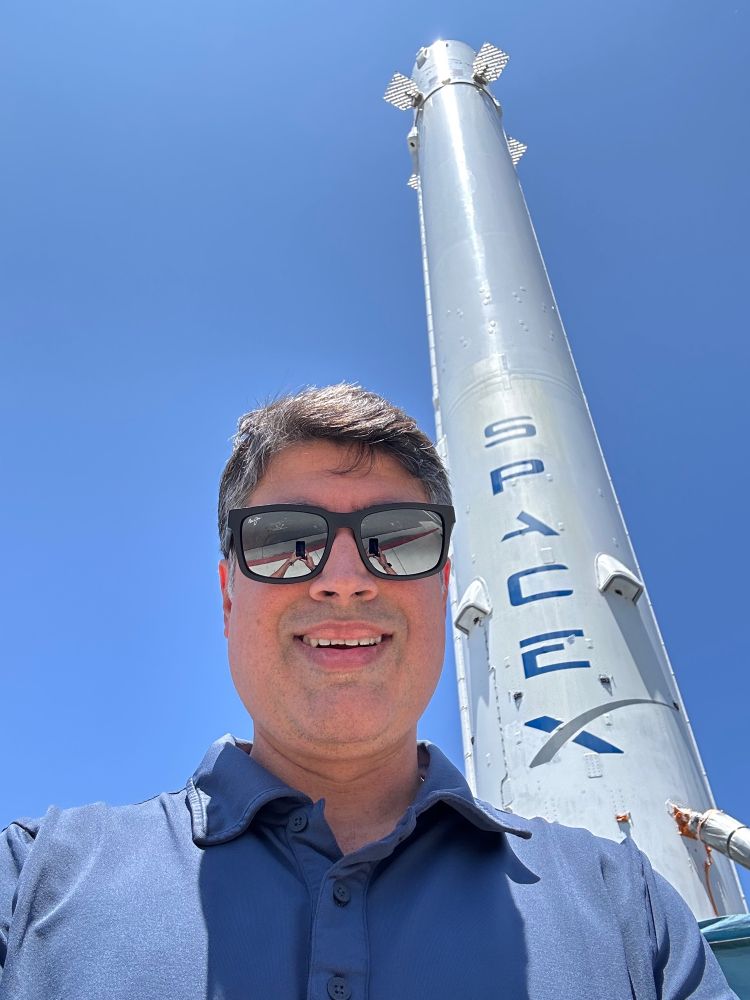 Man standing in front of a rocket.