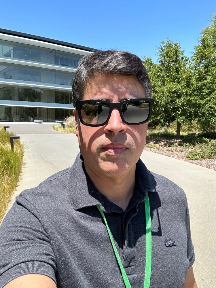 Middle aged man standing in front of a circular building.