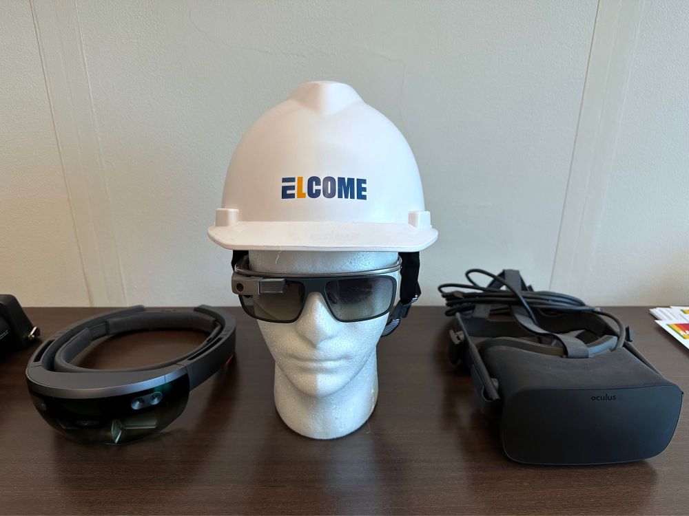 Photograph of a Microsoft HoloLens, Google Glass, and Oculus headset on display in my office.