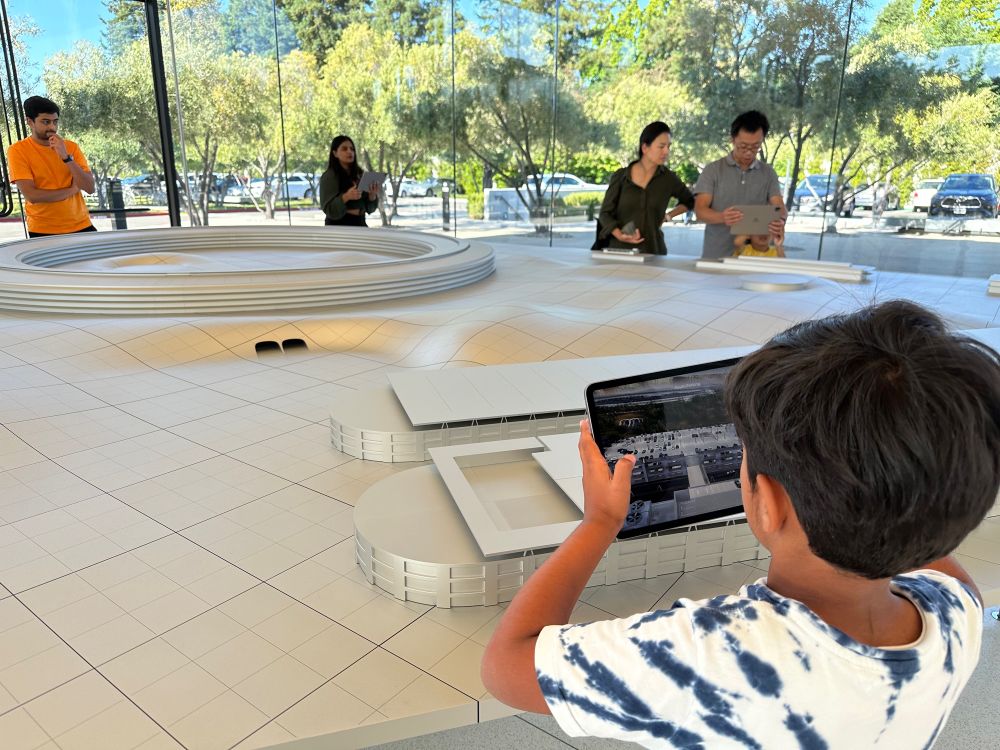 Boy holding an iPad to view an AR experience at the Apple Park Visitor Center in Cupertino, California.