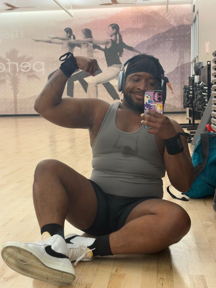 Picture of me flexing at the gym while sitting on the floor.