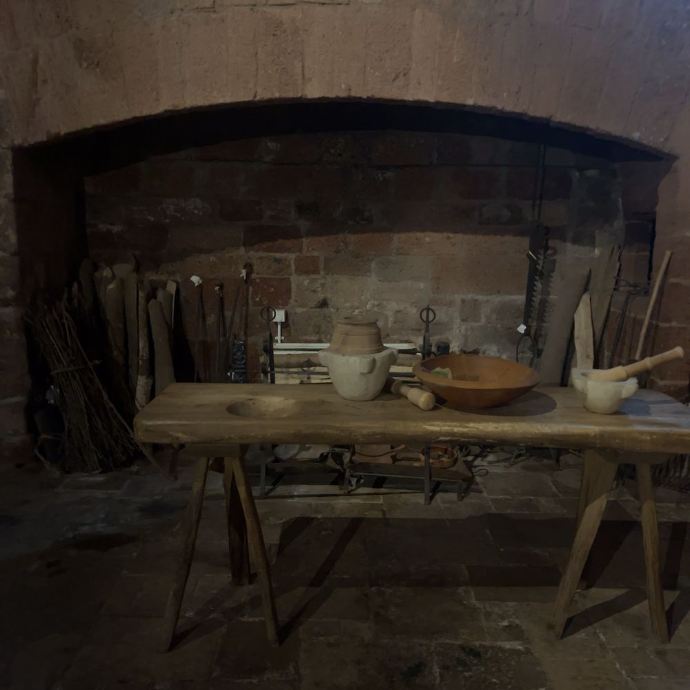 The kitchen - a table in front of a large fireplace 