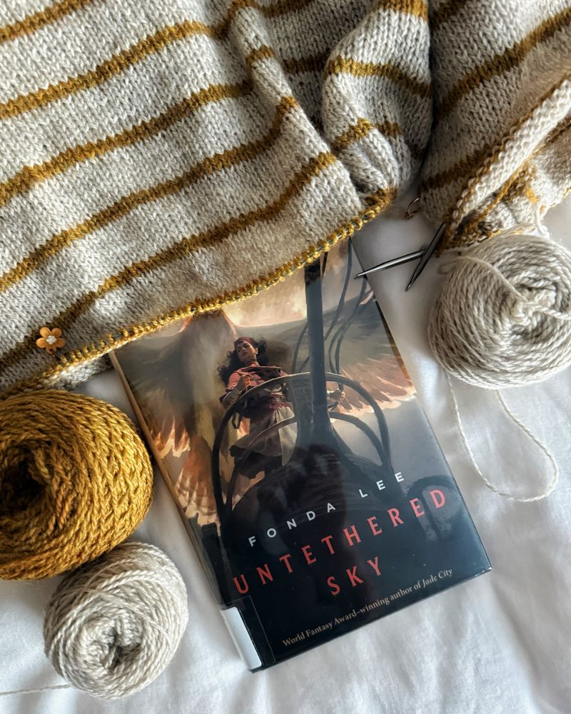 Close-up of hardcover book. Hardcover book features a young woman with dark hair standing on a chariot with an enormous bird flying above her.