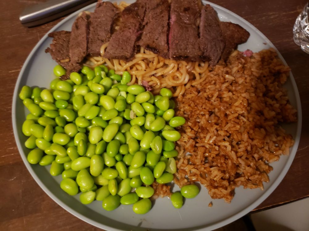 A plate of edamame, beef Bulgari, and fried rice with soy sauce

