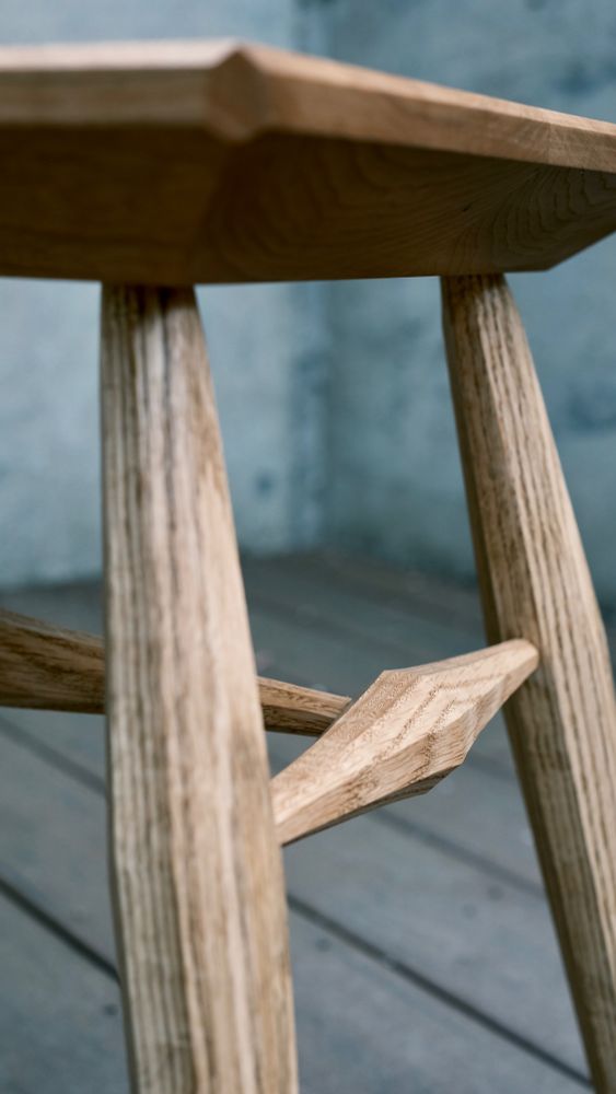 Close up of the side stretchers on a cherry and oak stool