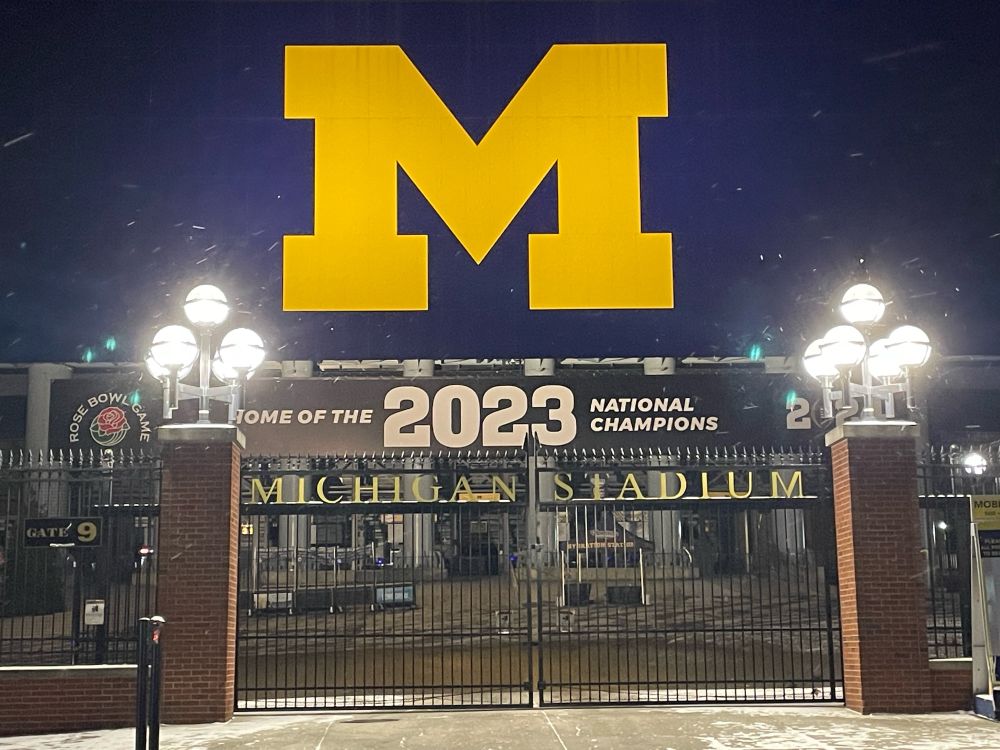 Photo of Michigan Stadium with 2023 championship banner, with a light snow falling 