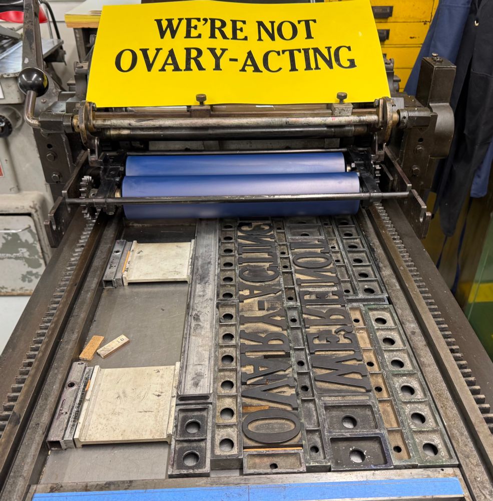 Placard on press: “We’re not Ovary-Acting