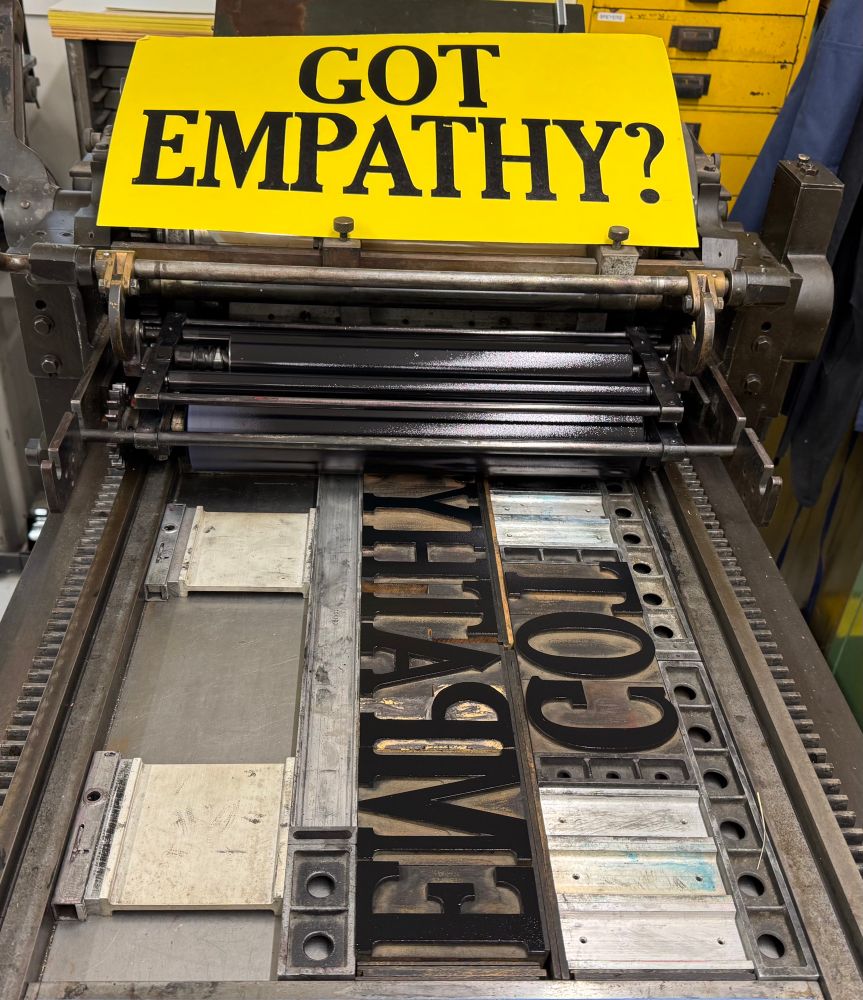 Placard sitting on on press: “Got Empathy?”