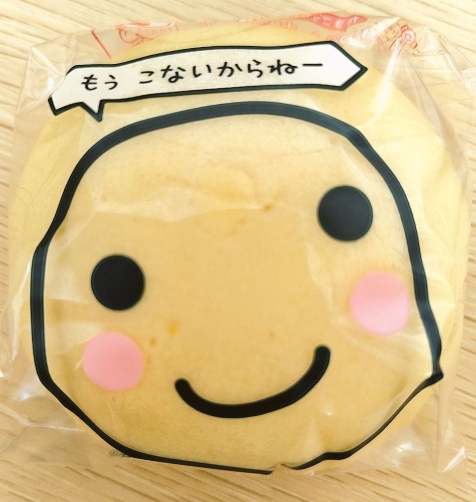 たまごっちのキャラクター「まるっち」が包装紙に書かれたカスタードまんじゅう。まるっちは「もう　こないからねー」と言っている。