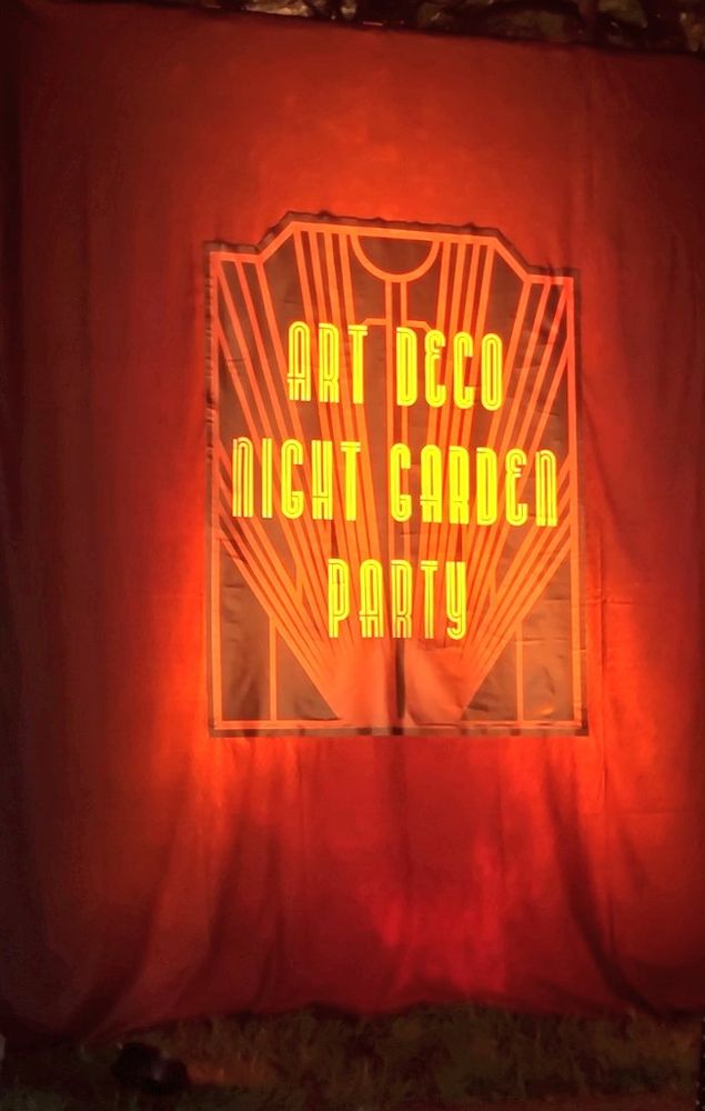 「ART DECO NIGHT GARDEN PARTY」とオレンジの字で書かれた赤い幕