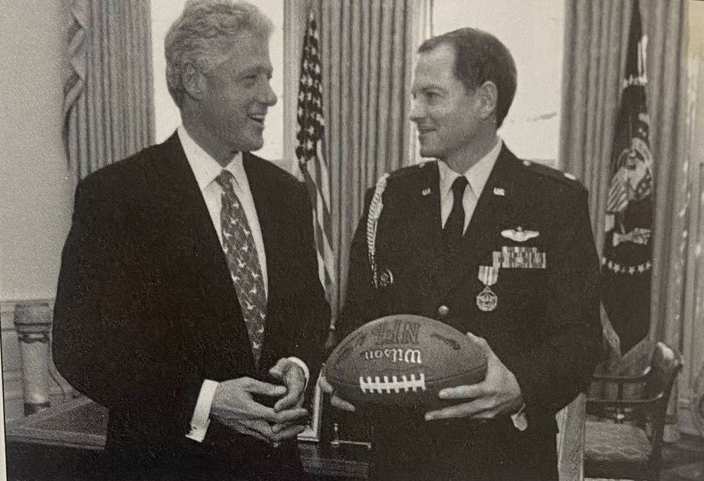 A black and white photograph of President Bill Clinton and Lt. Col. Robert 