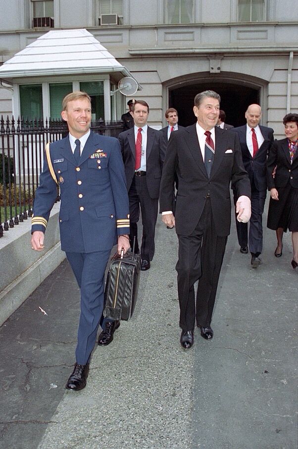 White House Military Office Coast Guard aide Lt. Commander Woody Lee carrying the President Emergency Satchel (aka the “Football”) while walking next to President Ronald Reagan (who had recently undergone surgery on his left hand), near the White House, January 10, 1989.