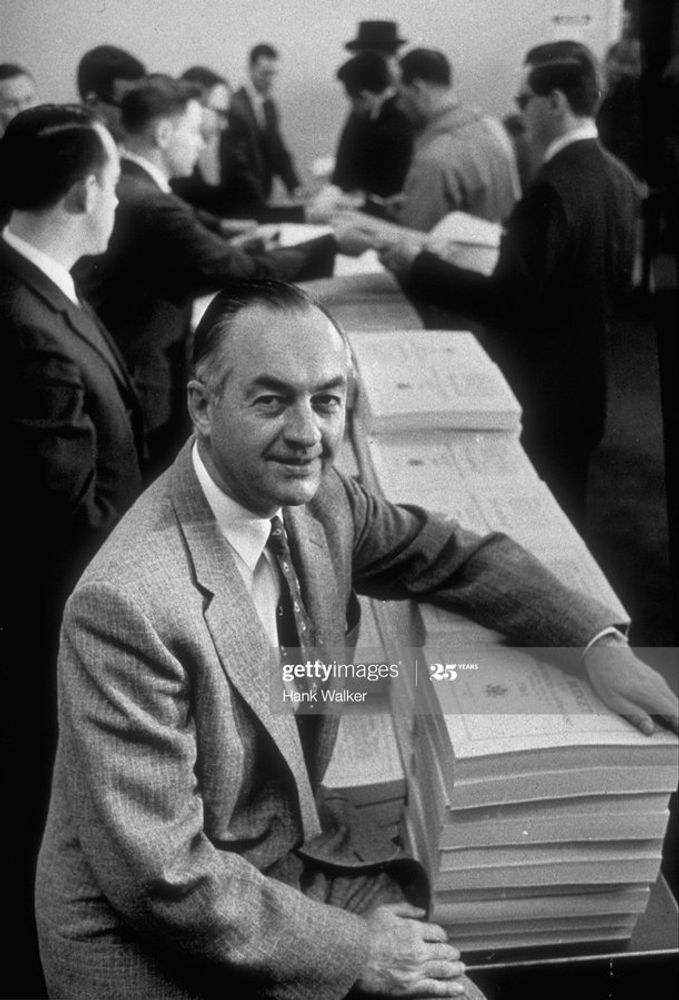A black and white photograph of Maurice Stans, when he was director of the Bureau of the Budget (the predecessor of the Office of Management and Budget), sitting on the edge of a table upon which are stacks of copies of the annual budget of the United States, which staff are handing out to journalists in the background.

Stans would go on to become Secretary of Commerce under President Richard Nixon, resigning in mid-1972 to become the finance chairman of his Committee for the Re-Election of the President (CREEP). In that role, he authorized the disbursement of campaign funds for some of the illegal activities conducted during the Watergate scandal, though he maintained he was unaware how the funds were being used. In March 1975, Stans pleaded guilty to two counts of accepting illegal campaign contributions and three counts of violating the reporting requirements of Federal Election Campaign Act and was fined $5,000.