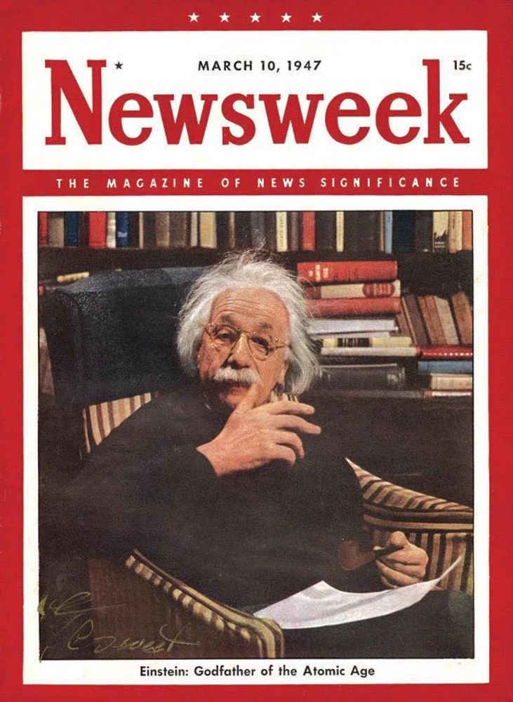 A photograph of the cover of the March 10, 1947, issue of Newsweek, featuring a large color photograph of Einstein sitting in a striped upholstered armchair in front of a filled bookcase in his office while holding a pipe, with the caption, “Einstein: Godfather of the Atomic Age.”