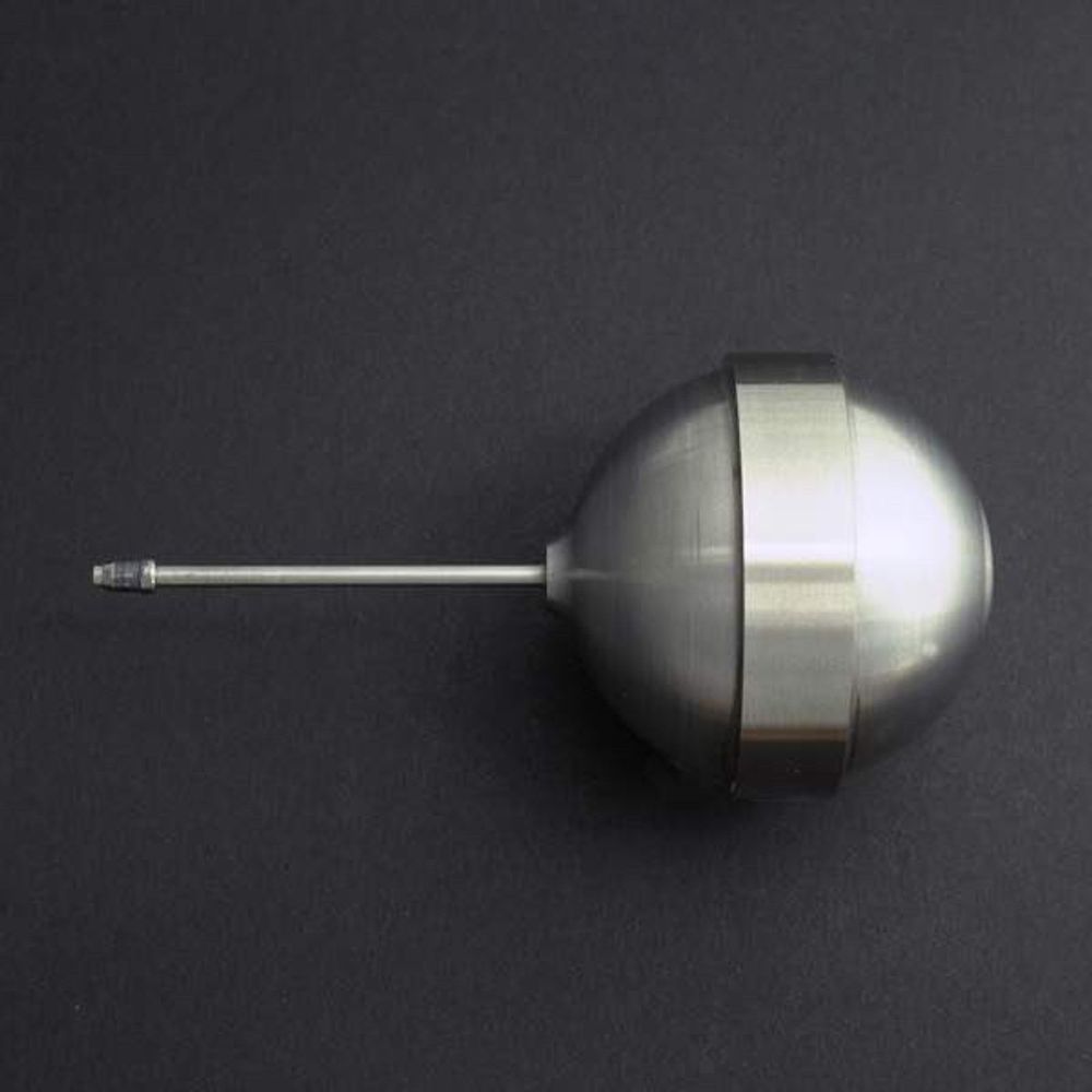 An official color photograph of a small metallic tritium reservoir, which resembles a bulb blower (used to clean camera equipment). The bulb portion of the reservoir is on the right. A thin metal tube with a tapered nozzle at the end protrudes from the bulb. No scale is given, but the reservoir is very small relative to the overall size of the bomb.
