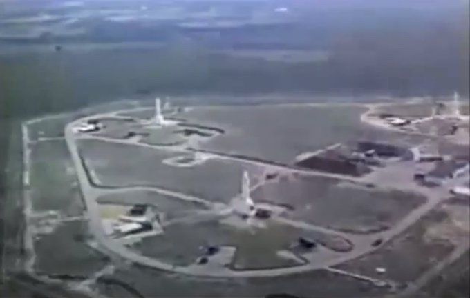 A low-resolution screenshot from a declassified color film showing a low-level aerial look at three Jupiter IRBMs deployed at Gioia Del Colle Air Base.