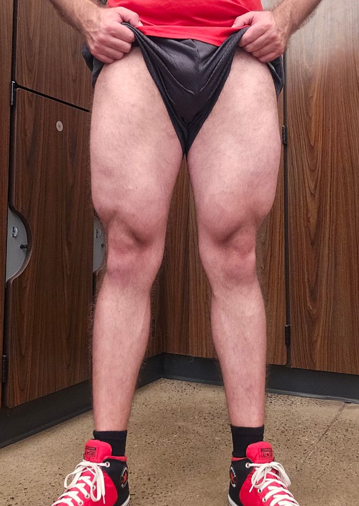 Kunaikun in a locker room pulling up his shorts and flexing his quads