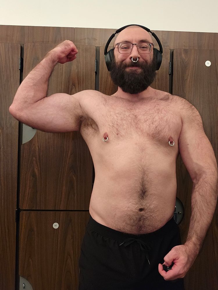 Kunaikun shirtless and flexing in a locker room 