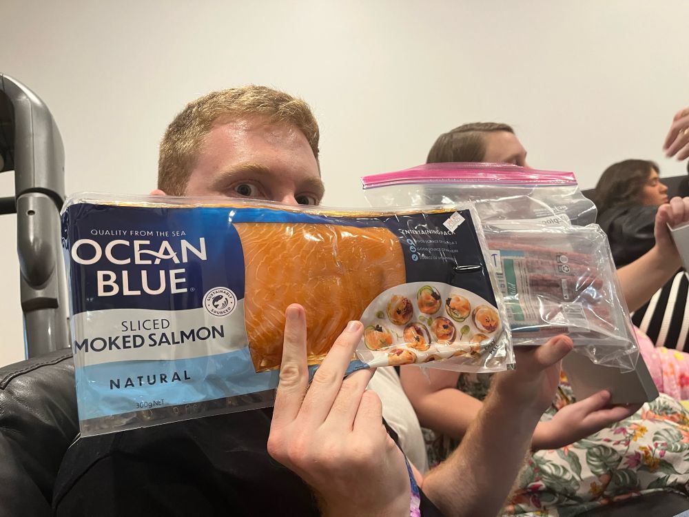 Scott holds up his Christmas presents, sliced smoked salmon and a box of twiggy sticks 