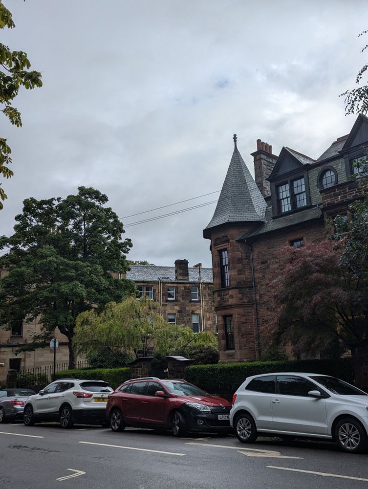 Streetscape - with building of red sandstone and turret, AND looming grey sky.