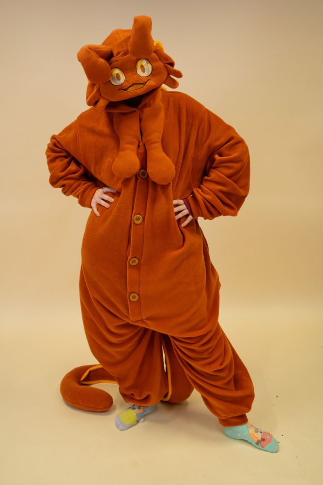 A photo of someone wearing a kigurumi that looks like the character Syrup the snail. They have their hands on their hips and head cocked to one side. 