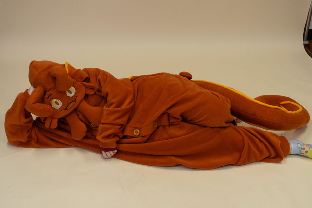 The same kigurumi being displayed in a cozy pose laying on the floor. 