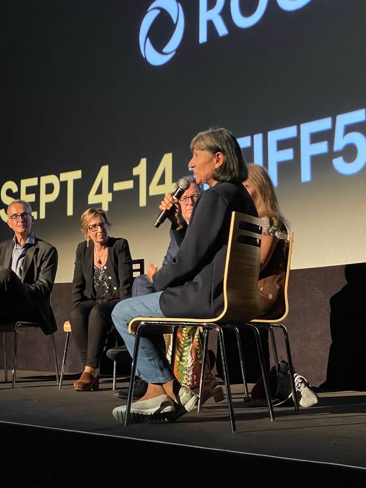Photo of Gloria, the main subject of the documentary Nuns vs. The Vatican, speaking on stage during the talkback after the film screening. She is joined by the director, producer, and executive producer. 