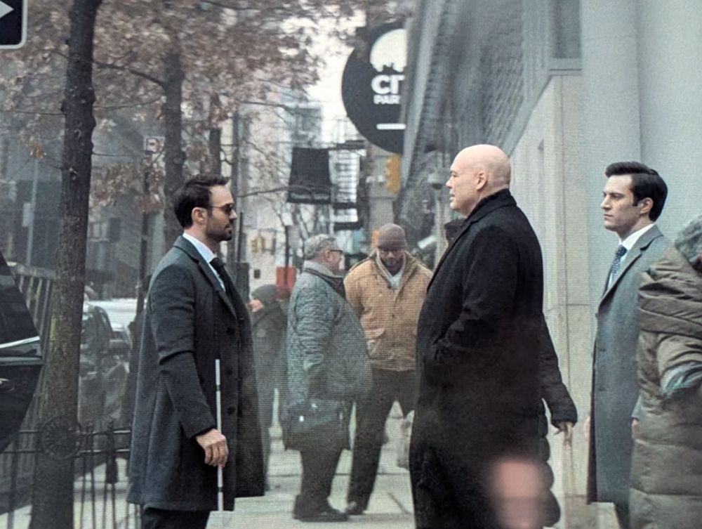 Matt Murdock and Wilson Fisk face to face on a sidewalk.