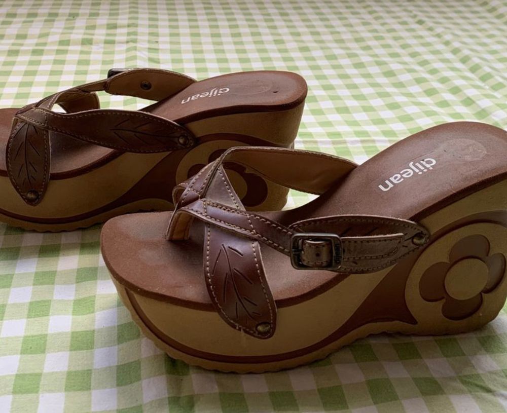 tamanco marrom da marca Djean. salto plataforma com uma flor na parte mais alta do salto, no calcanhar