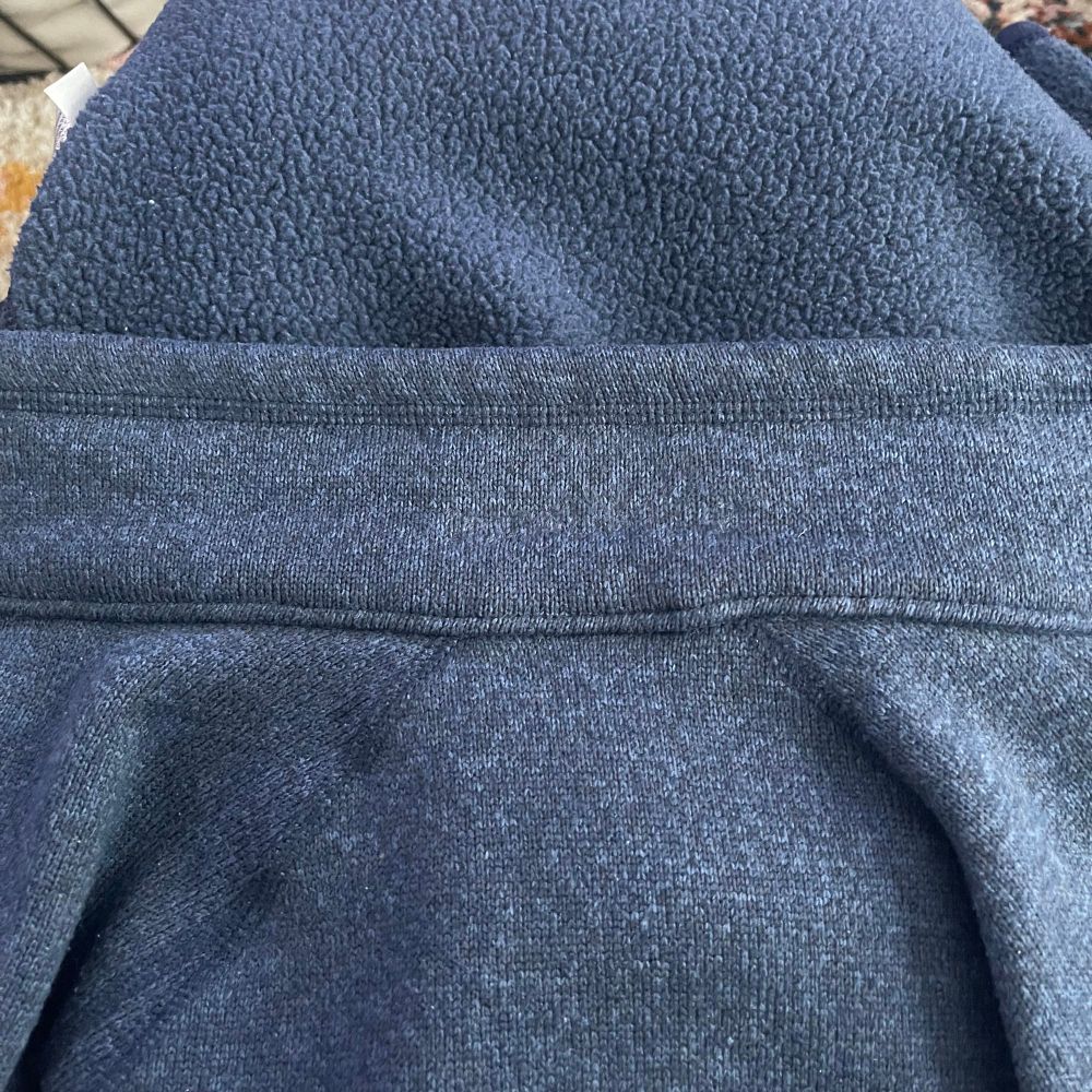 The same blue jacket but now the embroidered name is completely gone. 