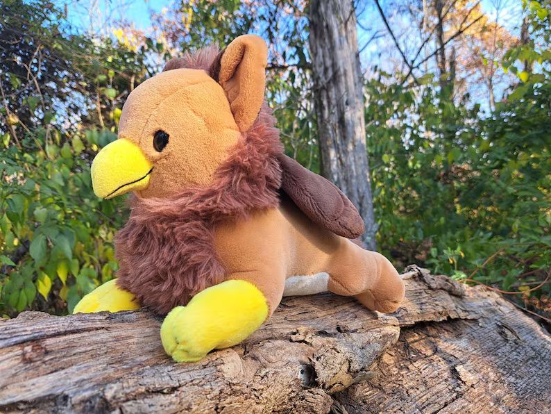 a brown gryphon plushie in a natural setting