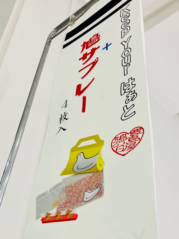 ハトの日記念商品のポスター。“keep your はぁと”＋鳩サブレーの文字と、鳩サブレー、鳩柄ジッパーバッグ、袋留めクリップの写真