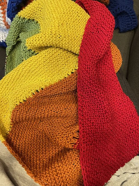 Photo shows a bunched up garter stitch shawl with a pale green stripe, orange stripe, yellow stripe, and red stripe. 

Pattern: Boom by Plays With Fibre
Yarn: Wee County Yarns Kinross 4-ply (rainbow mini-skeins)