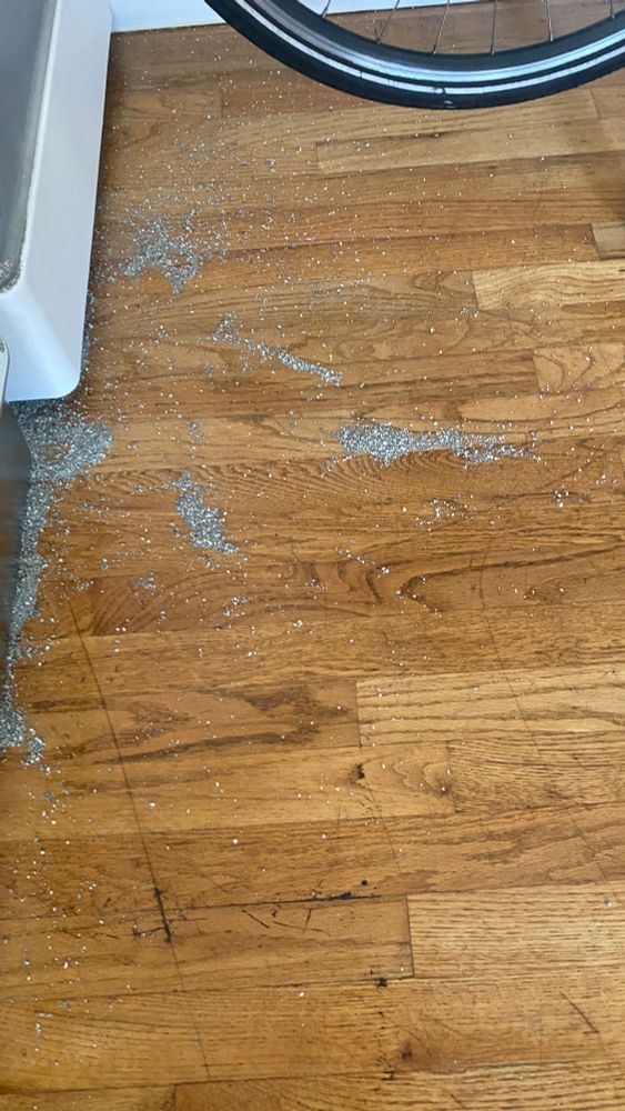 an abstract constellation of cat litter on a hardwood floor