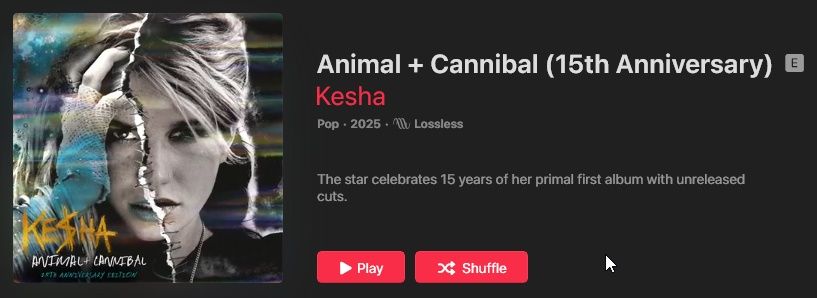 Capa do álbum digital “Animal + Cannibal (15th Anniversary)” da cantora Kesha exibida na interface do Apple Music em modo escuro. À esquerda, arte de capa colorida com predominância de azul, amarelo e roxo mostrando Kesha de perfil, com cabelos loiros esvoaçantes, maquiagem marcada e textura brilhante, além do logotipo “Kesha” em amarelo na parte inferior. No centro-esquerda há um grande retângulo cinza desfocado cobrindo parte da arte original. À direita, sobre fundo preto, aparecem o título “Animal + Cannibal (15th Anniversary)” em branco, o nome “Kesha” em rosa, a indicação de gênero “Pop”, ano “2025” e o ícone de áudio “Lossless”. Abaixo, texto curto descrevendo a celebração de 15 anos do primeiro álbum com faixas inéditas e, na parte inferior, dois botões grandes em rosa: “Play” à esquerda e “Shuffle” à direita, com um pequeno cursor em forma de seta próximo ao canto inferior direito da imagem.