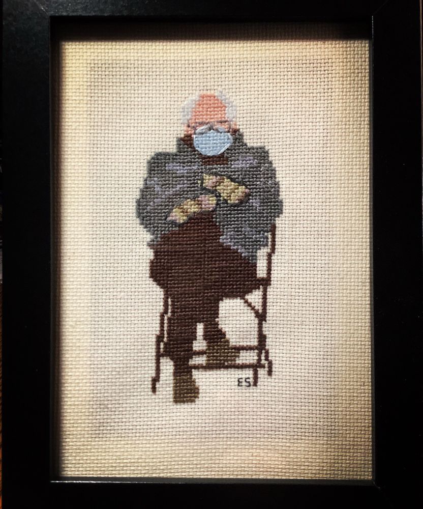 Cross stitch of Bernie Sanders in a mask and gloves at the inauguration 