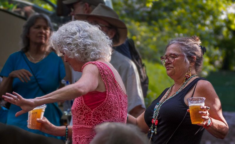 Street-festival attendees are dancing to live music while holding their beers.