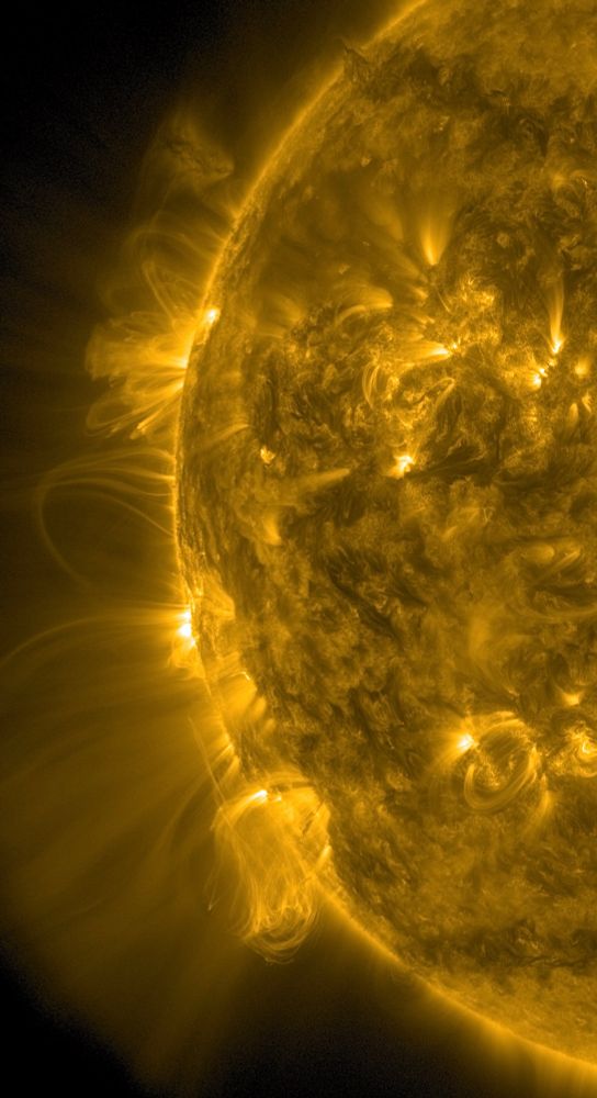 Der linke Rand der erdzugewandten Seite der Sonne in gelber Farbe. Mehrere Aktive Regionen mit weit ins All reichenden strahlenförmigen Strukturen. Unten auf der Zeigerposition acht Uhr deutet sich gerade eine Eruption in Form eines breiteren hellen Gebietes an, das aus der Sonne herauszuragen scheint.