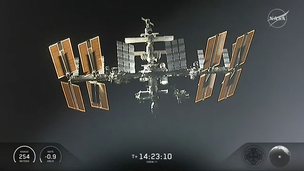Die ISS aus Sicht der Kameras des Dragon-Raumschiffs. In der Mitte die hellen röhrenförmigen Module, an den Seiten die großen Solarpanels.
