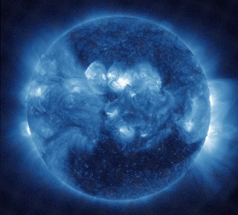 Die ganze erdzugewandte Seite der Sonne in blauen Farbtönen. Aktive Regionen besonders in der Mitte knapp über dem Sonnenäquator in heller Darstellung und etwas diffus wie weißliche Wolken aussehend. Im Gegensatz dazu ist nahezu der gesamte untere Bereich sehr dunkel wiedergegeben, was für ein sogenanntes koronales Loch spricht, eine Region in der Korona, also in der Atmosphäre der Sonne, das geringere Dichte als üblich hat und daher den Sonnenwind leichter durchlässt. Am seitlichen Rand und da besonders rechts weit ins All reichende Strahlen.