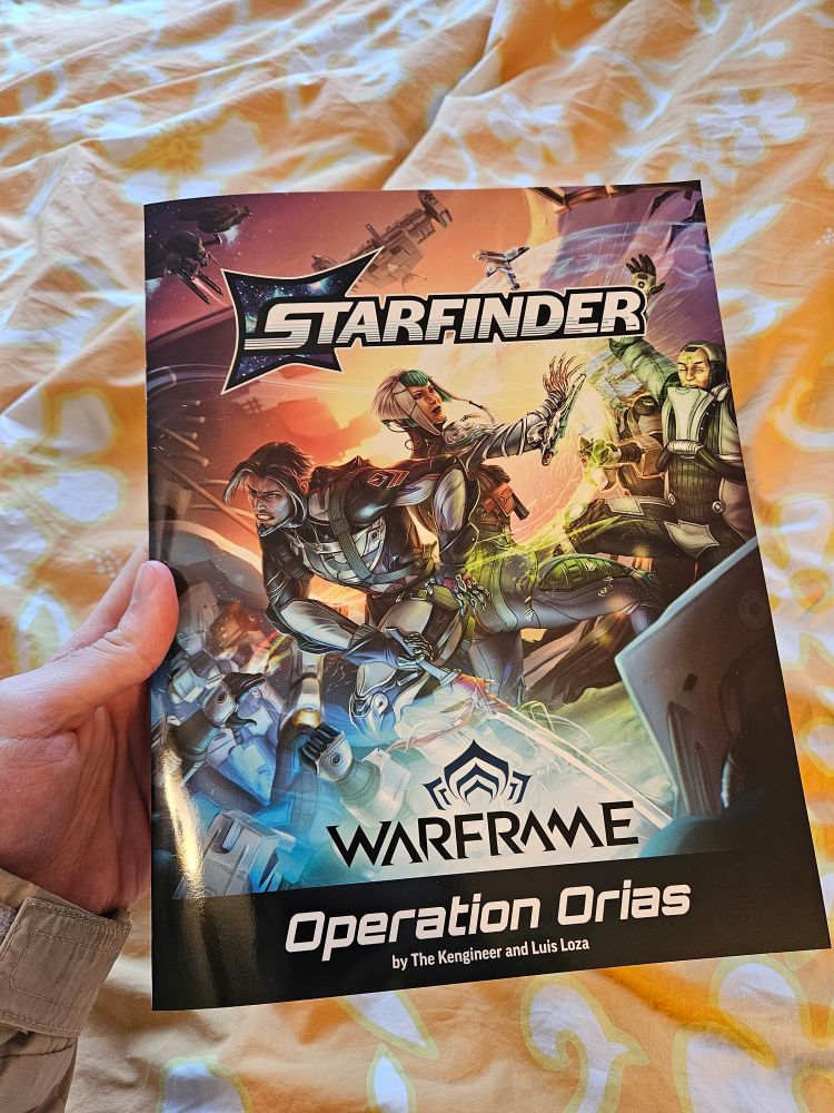 Photo of a copy of the Starfinder: Operation Orias module book, a crossover between Starfinder and Warframe
